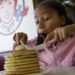 A kid enjoying a big stack of pan cakes at Wendys