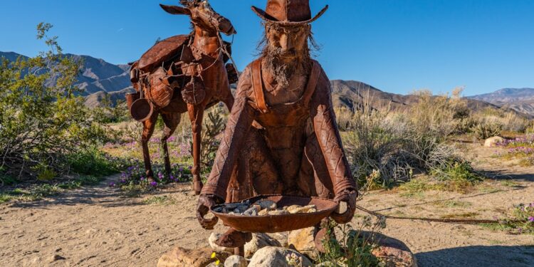A miner and his burro stride across the sand, echoing the hardship and hope of California’s frontier days.