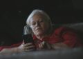 Oudere vrouw kijkt kritisch naar een bericht op haar smartphone