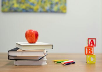 Stapel schoolboeken op een tafel in een klaslokaal