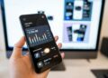 Smartphone met een crypto-app naast munten op tafel
