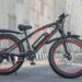 Jongere op een elektrische fatbike met brede banden op een fietspad in de stad