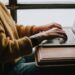 Iemand bekijkt een e-mail met een enquête op een laptop aan de keukentafel