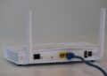 Witte wifi-router met twee antennes en een aangesloten netwerkkabel