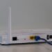 Witte wifi-router met twee antennes en een aangesloten netwerkkabel