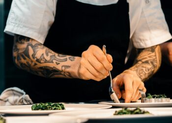 Chef-kok legt in een restaurantkeuken de laatste hand aan een gerecht