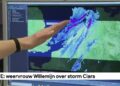 Meteoroloog wijst op een weerkaart waarop een storm boven de Noordzee richting Nederland trekt