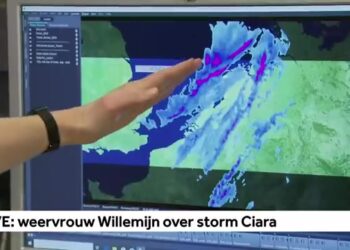 Meteoroloog wijst op een weerkaart waarop een storm boven de Noordzee richting Nederland trekt