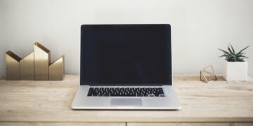 Werkzoekende bekijkt vacatures op een laptop aan de keukentafel