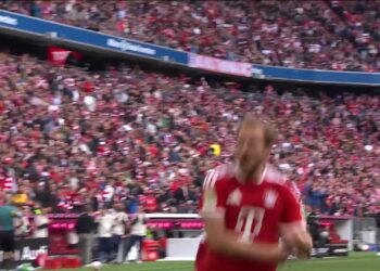 Harry Kane juicht in het shirt van Bayern München voor een volle tribune