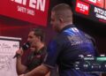 Darter Niels Zonneveld met zijn naam op het shirt naast de scheidsrechter tijdens de finale in Maastricht