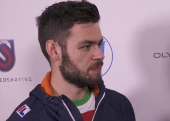 Sjinkie Knegt in een Nederlands trainingsjack tijdens een interview bij een wereldbekerwedstrijd shorttrack