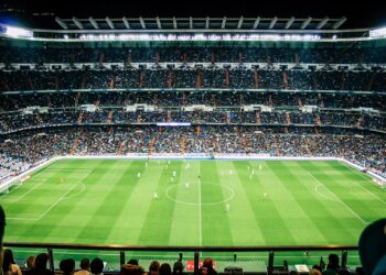Voetbalwedstrijd in een volle stadion bij avondlicht