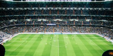 Voetbalwedstrijd in een volle stadion bij avondlicht