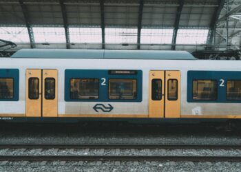 Reizigers op een perron bij een binnenrijdende trein