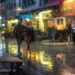 Regendruppels en een paraplu op een natte straat tijdens een bui