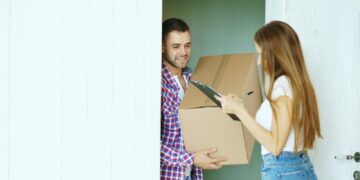 Pakketbezorger met een doos voor de deur van een woning