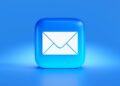 Iemand leest een e-mail op een laptop aan de keukentafel
