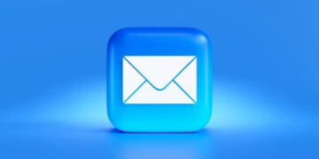 Iemand leest een e-mail op een laptop aan de keukentafel