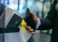 Telefoon die contactloos betaalt bij een betaalautomaat in een winkel