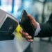 Telefoon die contactloos betaalt bij een betaalautomaat in een winkel