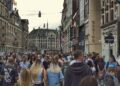 Mensen lopen door een drukke winkelstraat in een Nederlandse stad