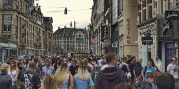 Mensen lopen door een drukke winkelstraat in een Nederlandse stad