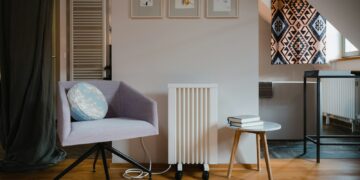 Radiator met thermostaatknop in een woonkamer met stadsverwarming