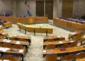 Lege plenaire zaal van de Tweede Kamer met de bankjes van de Kamerleden en het spreekgestoelte