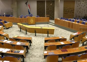 Lege plenaire zaal van de Tweede Kamer met de bankjes van de Kamerleden en het spreekgestoelte