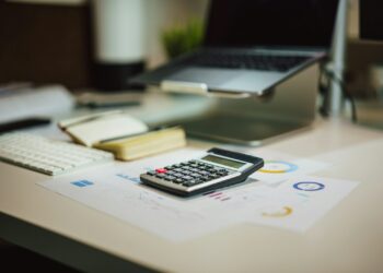 Brief van de Belastingdienst naast een laptop en een rekenmachine op een keukentafel