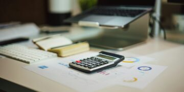 Brief van de Belastingdienst naast een laptop en een rekenmachine op een keukentafel