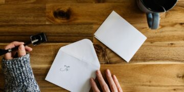 Iemand aan de keukentafel leest een officiële brief met loonstroken ernaast