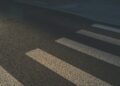 Voetganger steekt in het donker over op een zebrapad terwijl een auto nadert