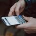 Iemand leest een verdacht sms-bericht op een smartphone
